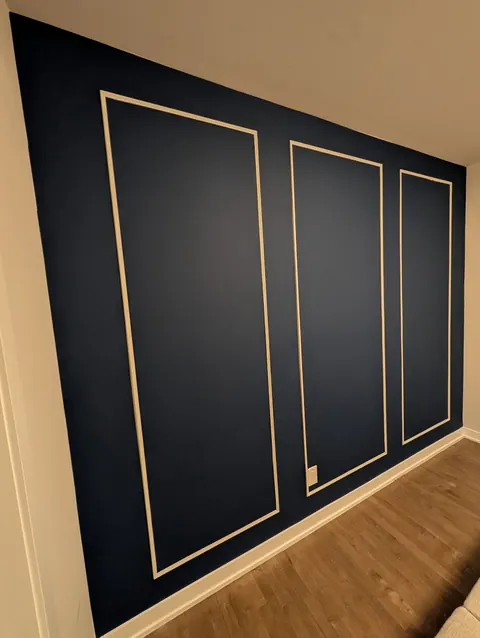 Navy wall with three tall white picture-frame mouldings