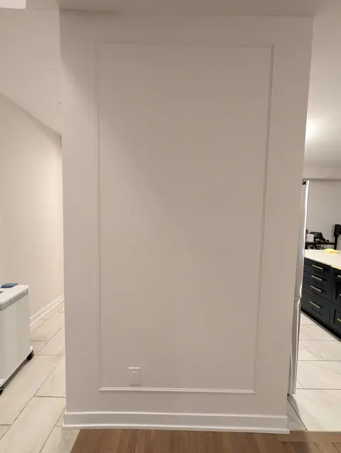 White wall with a tone-on-tone picture-frame moulding